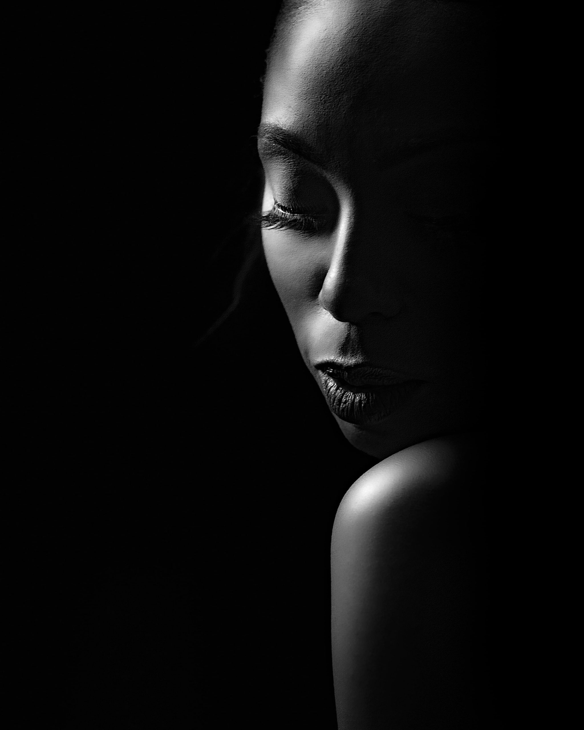A serene black and white portrait of a beautiful Black and white portrait of a Black woman with her eyes closed in a peaceful pose.
